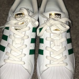Black and Gold Pumas and White and Green Adidas